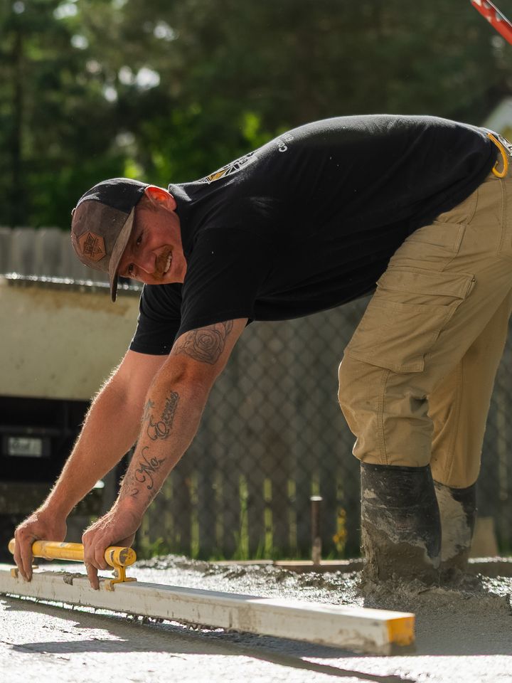 A&M Outdoor Services owner screeding a fresh concrete slab